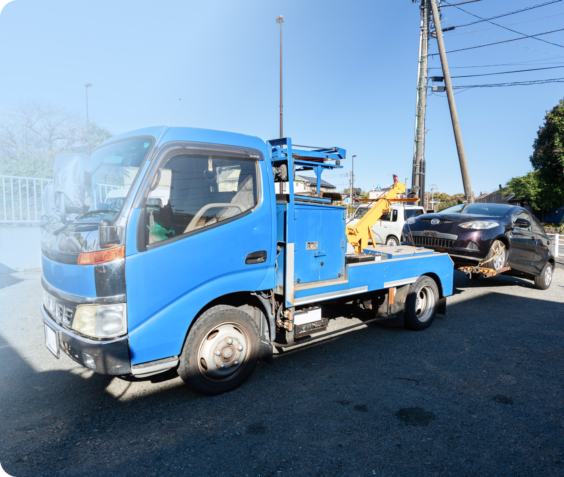 山崎商店のレッカー車が故障車を牽引している様子